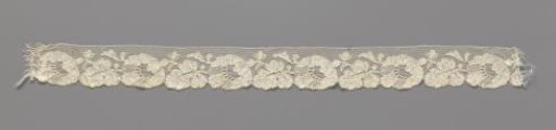 Strip of machine-made lace with horizontal flower followed by a horizontal leaf