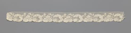 Strip of machine-made lace with a horizontal flower followed by a horizontal leaf