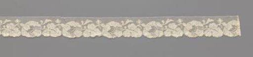 Strip of machine-made lace with a horizontal flower followed by a horizontal leaf