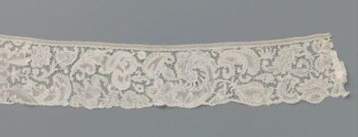 Strip of bobbin lace with rich symmetrical floral compositions