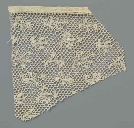 Fragment of bobbin lace with a scattered pattern of fantasy motifs