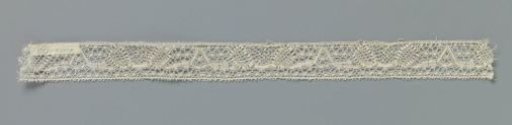 Strip of bobbin lace with triangle and two obliquely placed ovals
