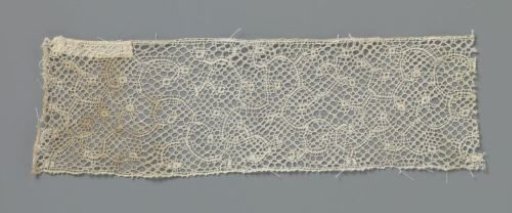 Strip of bobbin lace with sparse S- and C-shaped tendrils with oval knobs