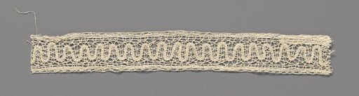 Insertion of bobbin lace with a wavy ribbon across the center line