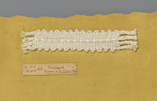 Steel bobbin lace with coarse thread as an example of a ribbon in linen stitch with decorative thread used in Russian ribbon lace