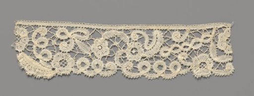 Strip of bobbin lace with rosette flowers and spirals