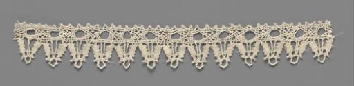 Strip of bobbin lace with triangular shells including a braided circle