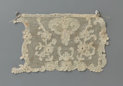 Strip of mixed lace with two rising branches bearing rosette flowers, between which a symmetrical motif with round forms and a hanging drop-shaped leaf