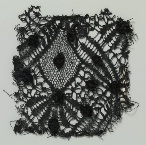 Fragment of bobbin lace with a scattered pattern of velvet dots