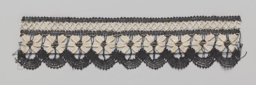 Strip of black-and-white bobbin lace with one row of daisies above half-round shells