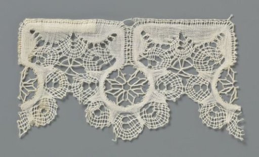 Strip of bobbin lace with lobed round shell with star or flower inside