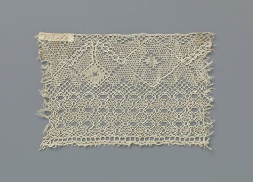 Strip of bobbin lace with diamonds above a border with columns
