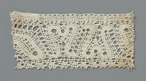 Strip of bobbin lace with mirrored S-motif