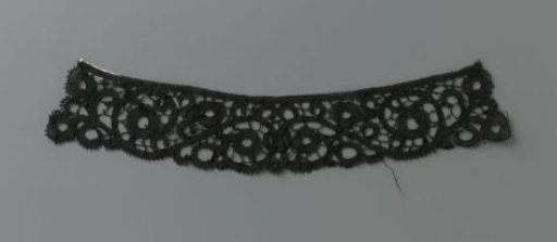 Collar or border of black bobbin lace with symmetrical spiral vines with oval flowers and open centers