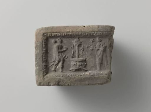 Fragment of a fireplace surround with an image of a man and woman at a fountain