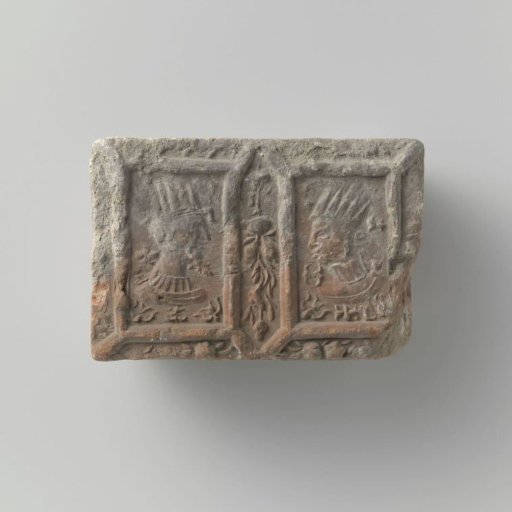 Fragment of a fireplace surround with an image of a crowned man's and woman's head, surrounded by festoons