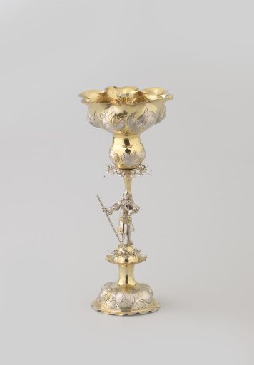 Hans-in-the-cellar. The flower-shaped lobed cup is supported by a male figure on a raised foot. In the cup a bell of leaves containing a child figure.