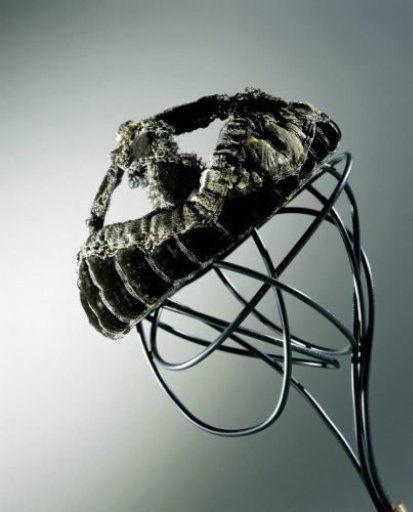 Wide-brimmed hat of black silk velvet with padded brim and two bands crossing over the head, decorated with silver passementerie and lace