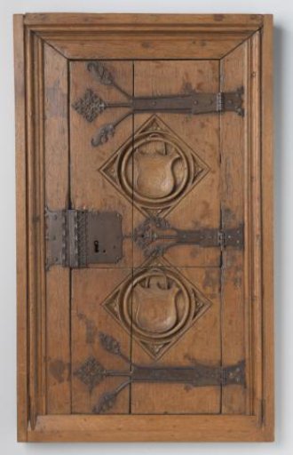 Door of a wall cabinet decorated with two relief-carved panels containing coats of arms