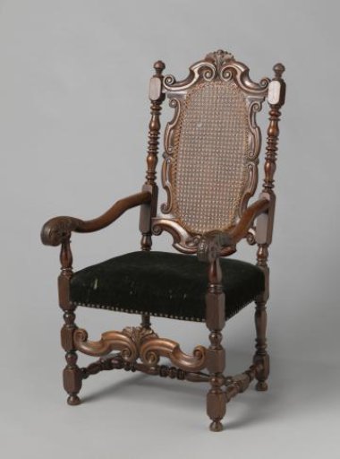 Armchair with upholstered seat and back with caned covering. Decorated with broken S-scrolls, rosettes, and acanthus leaves