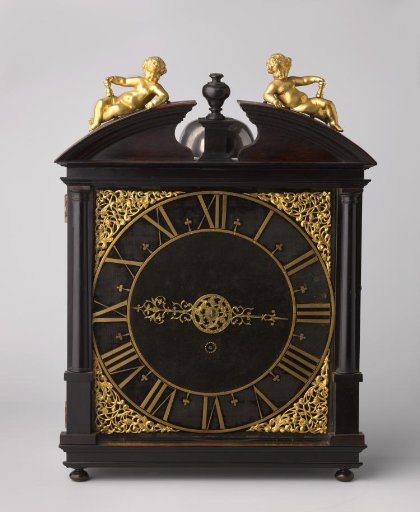 Table clock of wood; square case on flattened ball feet, between two Tuscan half-columns