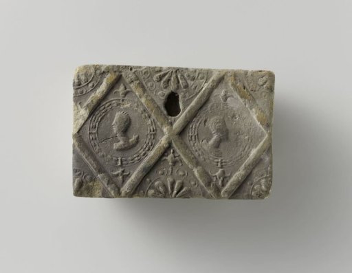 Fireplace surround with a diamond ornament featuring two heads