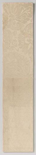 Fragment of white silk damask with a pattern of two flowers on a curved stem with a heraldic lily