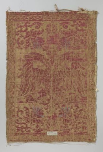 Fragment of a canvas of yellow and red satin brocade with a pattern of double crowned eagles and floral ornaments in the corners