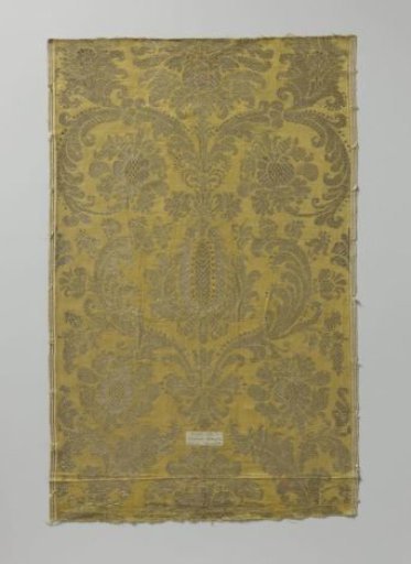 Fragment of silk fabric with gold and silver thread on a yellow ground. Pattern of palmettes, acanthus leaves, stylized flowers and pomegranates
