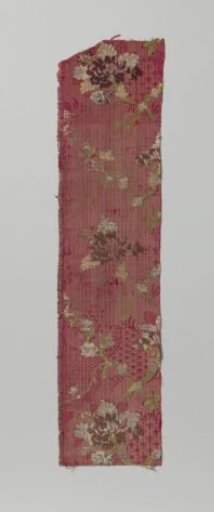 Fragment of red brocaded silk with a multicolored pattern of bouquet and floral garlands and so-called kantrand