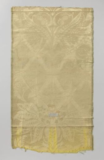 Fragment of yellow silk damask with a large pattern of stylized fan-shaped spread leaves between flowers and fruits