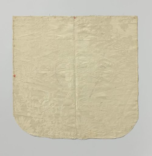 Fragment of white silk damask with a pattern of floral scrolls and finials