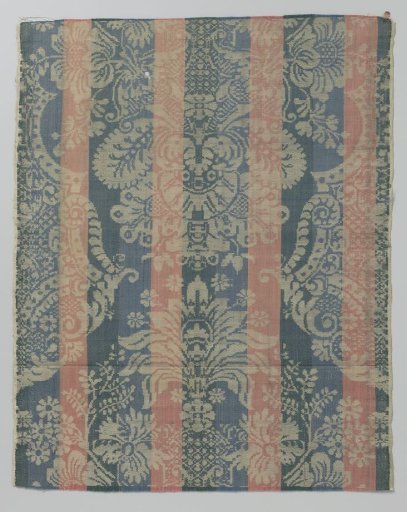 Fragment of coarse linen fabric with a floral pattern on a striped background