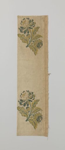 Fragment of brocaded silk with a flower in yellow and green