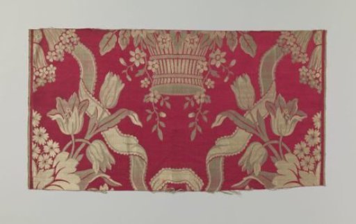 Fragment of red silk fabric with flowers in blue and white