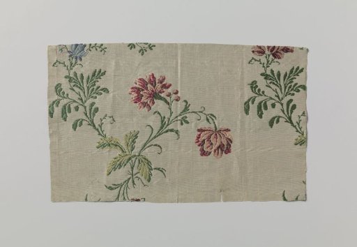 Fragment of white brocaded silk with multicolored flower branches
