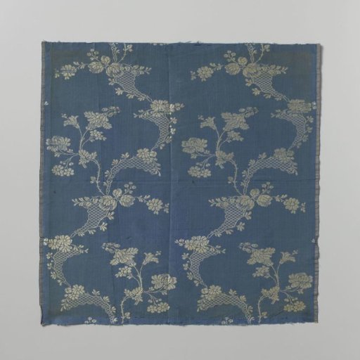 Fragment of blue brocaded silk with a white pattern