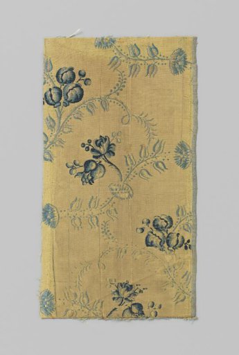 Fragment of yellow and blue shimmering silk with blue and white vines and flowers