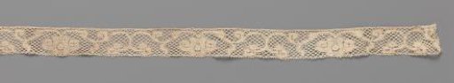 Strip of bobbin lace with a flower in the middle of a scrollwork vine