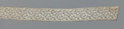Strip of bobbin lace with a tangle of oval knobs