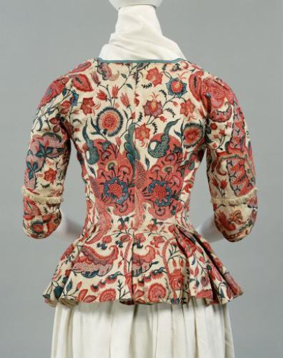 Jacket with square collar, of chintz with large, whimsically shaped leaf ornaments and small carnation-like flowers; sleeve with fringe above the elbow