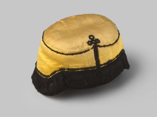 Cap of yellow satin, trimmed with black passementerie and decorated with black beads