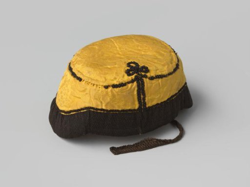 Cap of yellow damask, adorned with black coral and trimmed with black passementerie