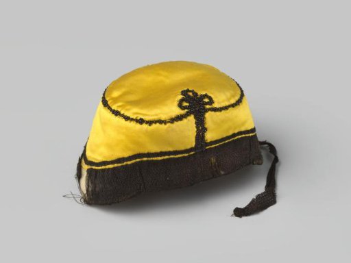 Cap of yellow satin, adorned with black coral and trimmed with black passementerie