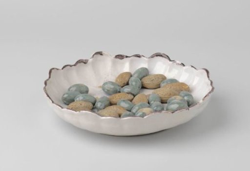 Plate with a scalloped rim and applied olives and almonds