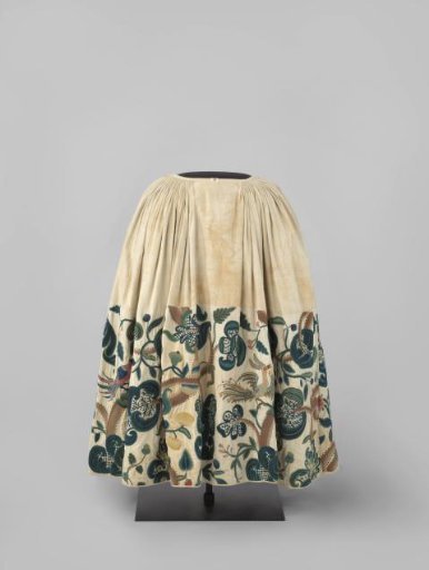Skirt with side slits and white linen lining of heavy white twilled cotton, multicoloured in wool embroidered with heavy flower, leaf and fruit motifs, broad branches and birds