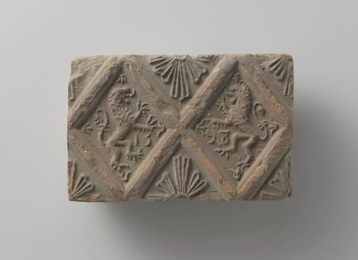 Fired fireplace tile, with panes containing climbing lions and fan-shaped stars