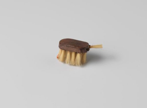 Brush with oval back, with bristles on the underside and one of the short sides