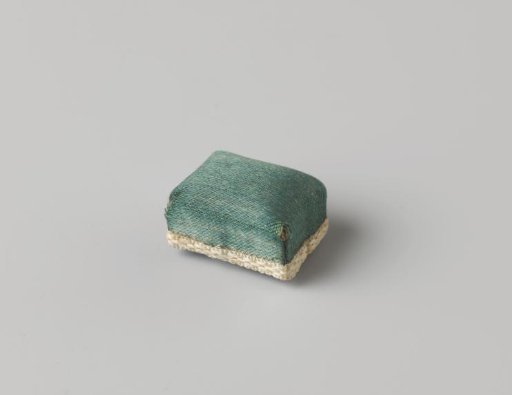 Pincushion, covered with green-blue silk, trimmed with white ribbon