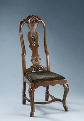 Chair with a loose cushion attached to the back and S-shaped legs placed diagonally, ending in hoof feet